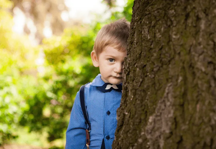 boy behind a tree