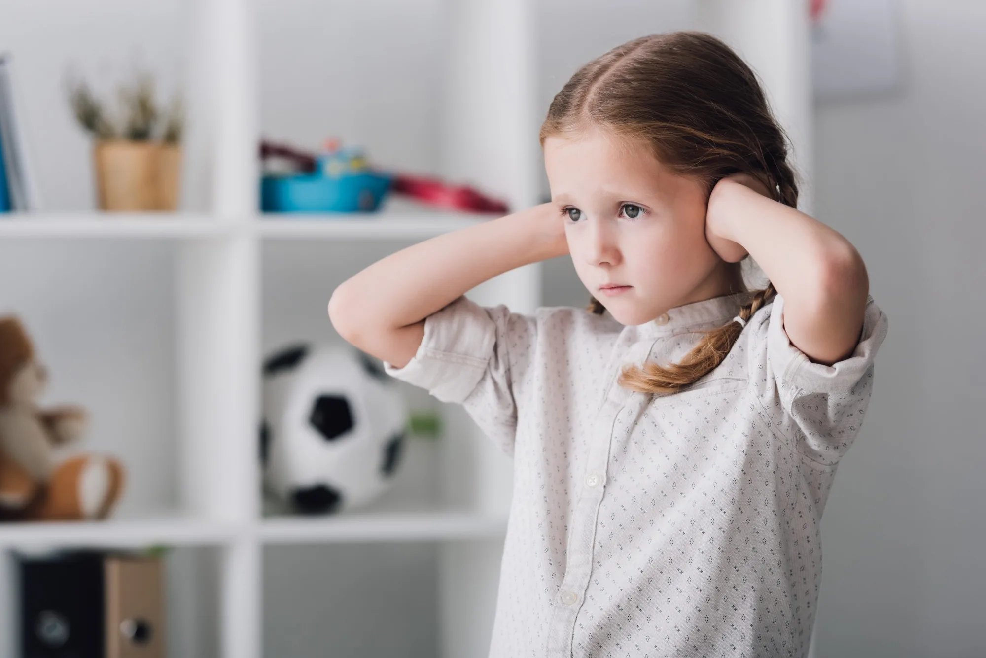 sensitive girl holding her ears